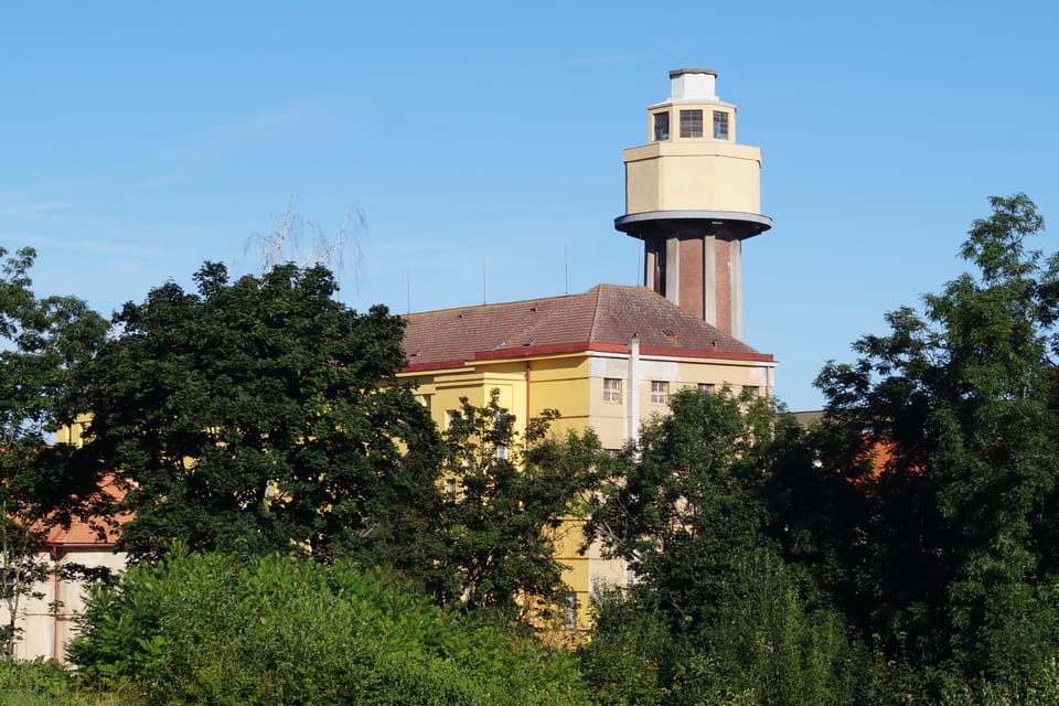 Le château d’eau de Ruzyně est le bâtiment le plus haut du terrain de la prison de ce quartier à l'ouest de Prague. La cheminée de l’usine à sucre d'origine a été construite dans les années 1930 avec des piliers en béton armé qui soutiennent le résevoir. | Photo: Miloš Turek, Radio Prague Int. Le château d’eau de Ruzyně est le bâtiment le plus haut du terrain de la prison de ce quartier à l'ouest de Prague. La cheminée de l’usine à sucre d'origine a été construite dans les années 1930 avec des piliers en béton armé qui soutiennent le résevoir. | Photo: Miloš Turek, Radio Prague Int.
